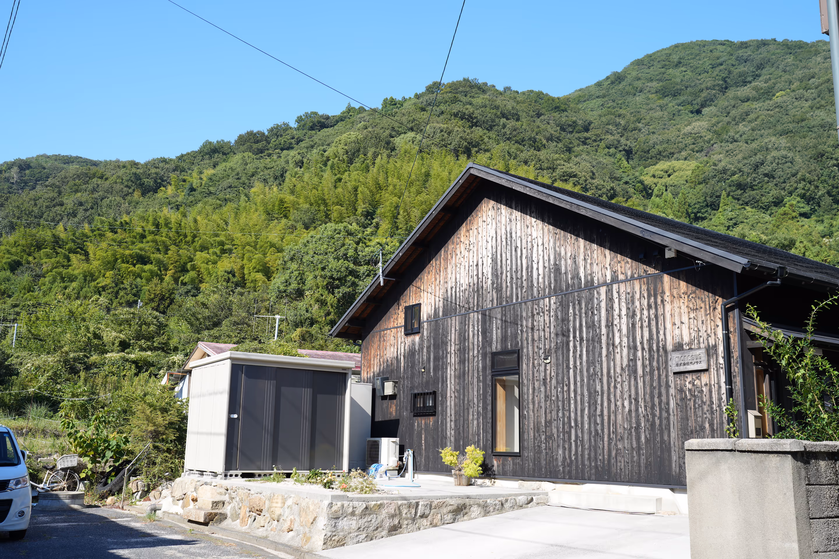 An atmospheric wooden building nestled in the lush green nature of the mountains.