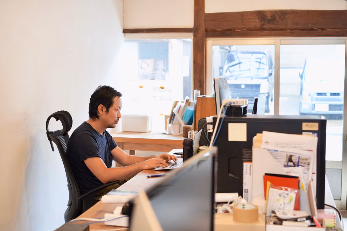 A man is working on a computer in his office.